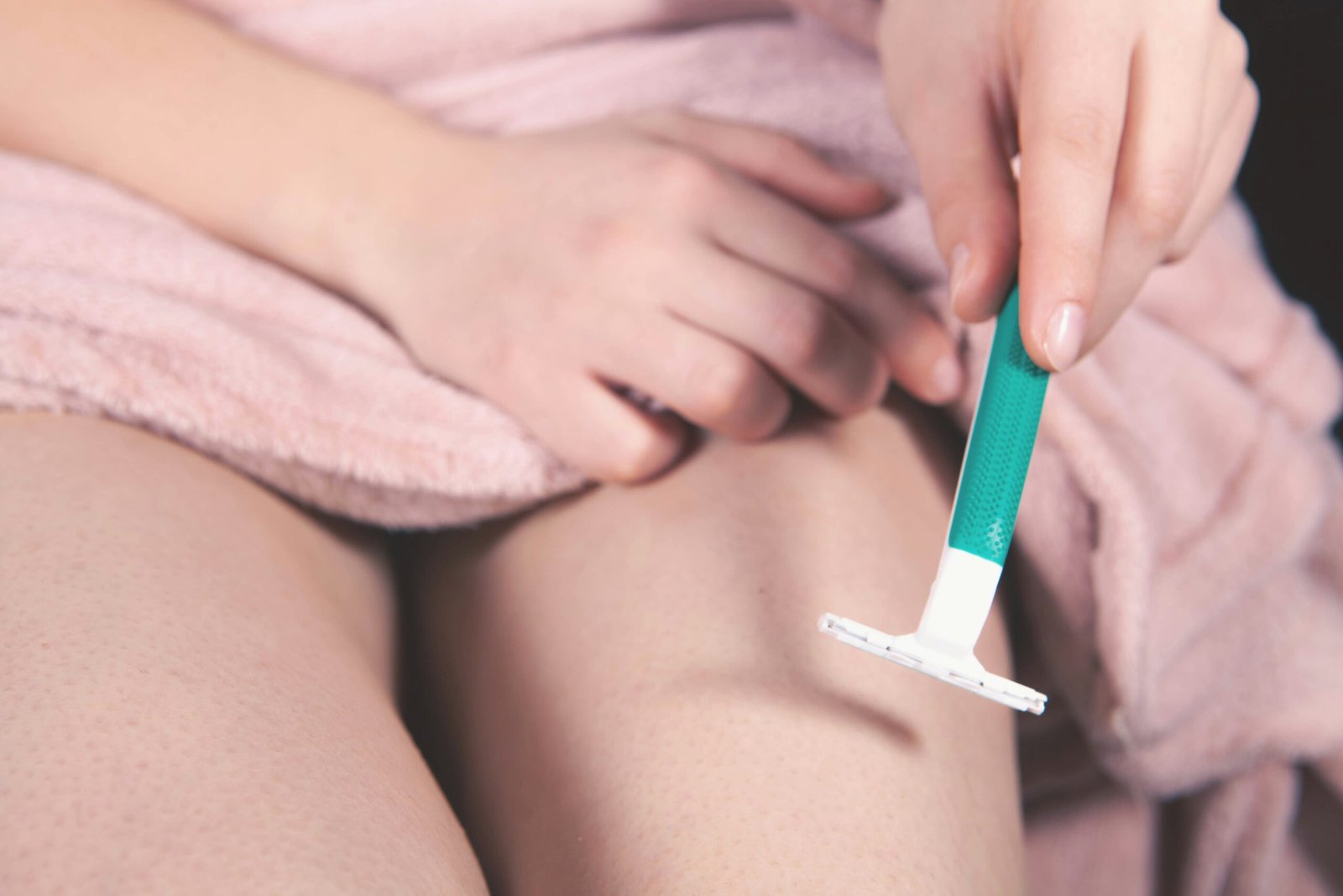 Person shaving leg with razor